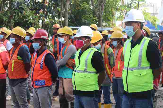 Ropa de Trabajo group of people wearing orange hard hat and backpacks